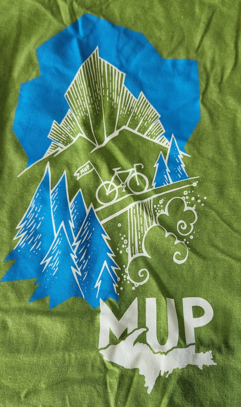 Product Description: This MUP branded t-shirt celebrates our Upper Peninsula’s tour. Even when you're not riding on one of our tours, you can show your love of them with these great cotton tees.</br> MUP GREEN COTTON T-SHIRT