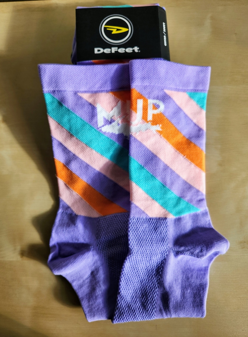 Product Description: The MUP socks match the 2023 jersey!</br></br>The Aireator is the sock that started DeFeet, designed in 1992 as the first cycling sock with an open mesh weave instep for breathability and moisture wicking. The lightweight and durable Aireator is available in a single and a double cuff, with the double cuff providing additional compression in the ankle zone to prevent slipping. This sock has a close fit in performance cycling shoes, and the fiber blend includes Repreve®, a recycled performance polyester locally manufactured from recycled plastic bottles, reducing landfill waste.</br> 2023 MUP Socks